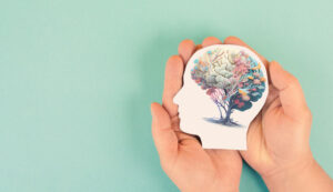 hand holding paper human brain of flowers