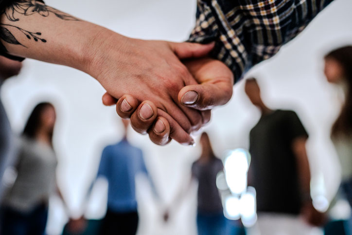closeup of circle group holding hands