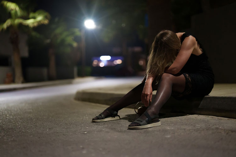 drunk woman slumped over on the street curb