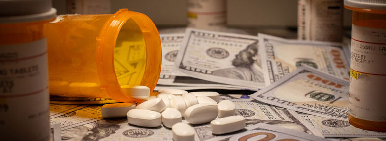 money and prescription pills and bottles on table