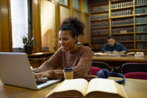 student concentrating on computer in library