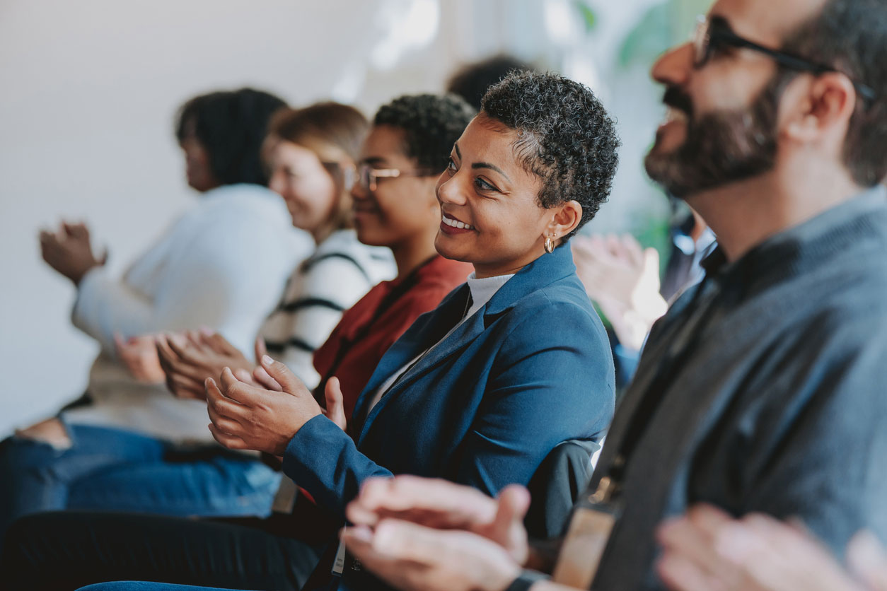 group of professionals applauding speaker